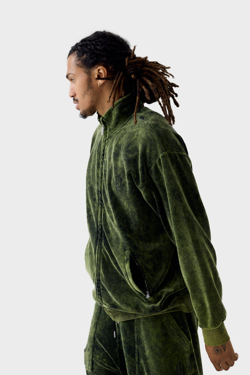 Side profile of model wearing lime acid-wash velour zip-through track jacket zipped up; features acid-wash texture, black crystal branding, ribbed collar, zipped side pockets and elastic hem.