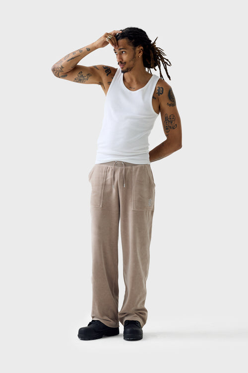Full-body view of beige velour straight track pants and matching jacket; pants have drawstring waistband, rhinestone 'DL' logo patch pocket and relaxed wide leg.